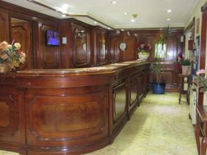 a large kitchen with wood paneling and a bar at Hotel Ciudad de Vitoria in Santiago