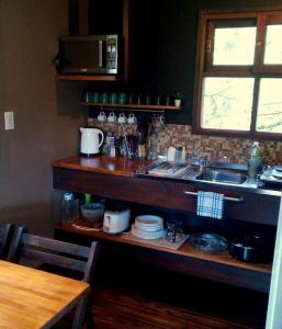 een keuken met een aanrecht met borden en een wastafel bij Posta Chimango, Cabañas frente al Golf Los Acantilados in Mar del Plata