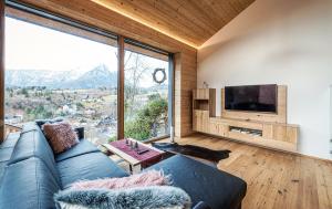 a living room with a blue couch and a large window at Am Sonnenhang in Bad Aussee