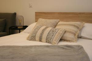 Una cama con dos almohadas encima. en Le Melsono Carré d'Or, en Niza