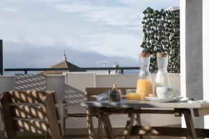 een tafel en stoelen op een balkon met uitzicht op de oceaan bij Posada del Herrero in Madridejos