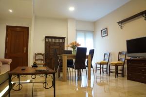 a living room with a dining room table and chairs at Dúplex Centro Parking Ronda in Ronda