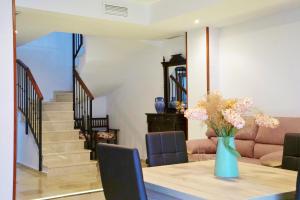 a dining room with a vase of flowers on a table at Dúplex Centro Parking Ronda in Ronda +32 photos