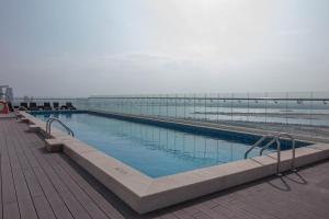 a swimming pool next to the ocean with a pier at In Healthcare City, Newly Furnished, 1BR Azizi Aliyah in Dubai
