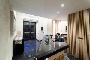 a man sitting at a counter in a kitchen at Royal House Napoli Centro, by ClaPa Group in Naples