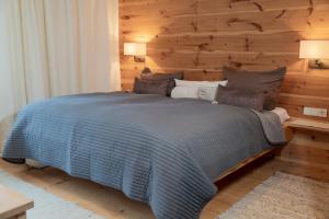 ein Schlafzimmer mit einem großen Bett und einer Holzwand in der Unterkunft BnB44 only rooms no breakfast in Bichlbach