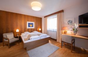 Schlafzimmer mit einem Bett, einem Schreibtisch und einem TV in der Unterkunft Appartements Falkner Dorli in Oetz
