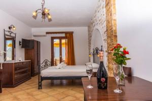 Un dormitorio con una cama y una mesa con una botella de vino en Summer Dream II, en Agia Anna de Naxos