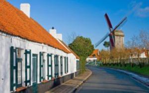 een straat naast een gebouw met een windmolen bij Hotel Adagio in Knokke-Heist