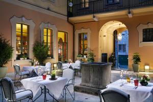 een restaurant met witte tafels en stoelen en een fontein bij Villa Appiani Hotel in Trezzo sullʼAdda