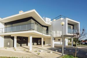 een groot wit huis met veel glas bij Janelas de Salir - By SCH in Salir de Porto