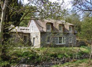 una vieja casa de piedra en medio del bosque en Forget Me Not Holiday Cottage en Dalmellington