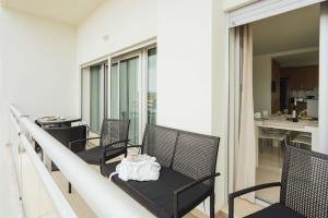 a row of chairs on a balcony with a table at Dunas - Holiday Apartments - By SCH in Salir de Porto