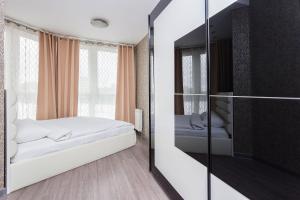 a bedroom with a bed and a mirror at Apartment Roomer 6 in Minsk