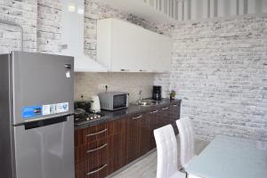 eine Küche mit einem Kühlschrank und einem Tisch mit weißen Stühlen in der Unterkunft Studio boutique apartment in Bischkek
