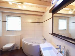 a bathroom with a tub and a toilet and a sink at Ferienhaus Ostseeblick 236 in Baabe +17 photos