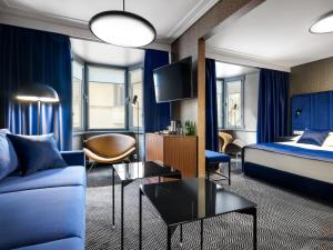 a hotel room with a bed and a couch at Hotel Logos Kraków in Krakow