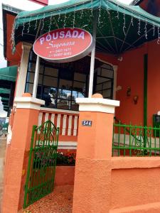 a restaurant with a sign in front of a building at Pousada Sayonara in Atibaia