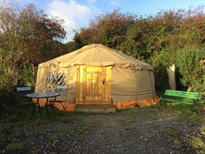 a yurt with a table and a green bench at Inch Hideaway Eco Camping in Whitegate