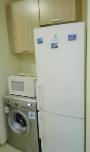 a white refrigerator in a kitchen with a washing machine at Двухкомнатная квартира Smart-Home in Daugavpils