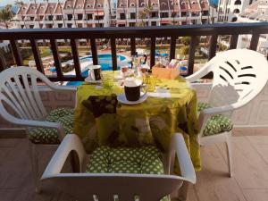 a table with a yellow table cloth on a balcony at Golden View Holiday Home in Playa de las Americas