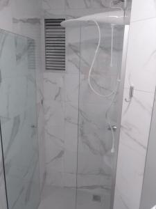 a shower with a glass door in a bathroom at Meia Praia com 3 Quartos com Wifi e Ar - Beira Mar in Itapema