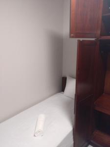 a small room with a white bed with a cupboard at Meia Praia com 3 Quartos com Wifi e Ar - Beira Mar in Itapema