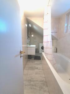 a bathroom with a tub and a toilet and a sink at Landhaus Haser in Oberammergau +34 photos