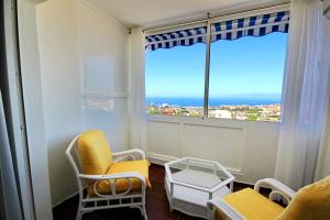 a room with two chairs and a large window at Cozy Townhouse With Ocean Views in Costa Adeje in Adeje