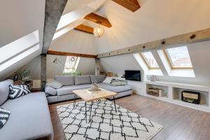 a living room with a couch and a table at Grand Apartments - Wood Loft Apartment in Sopot