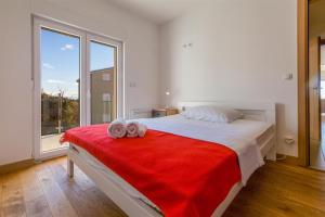 a bedroom with a large bed with two towels on it at WHITE HOUSE PENTHOUSE in Dramalj