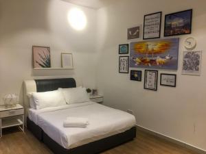 um quarto com uma cama e quadros na parede em Zayah Homestudio near Bukit Jalil / Mines em Seri Kembangan