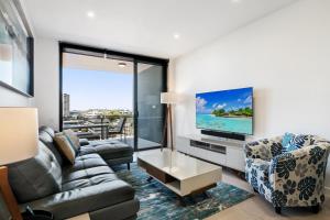 a living room with a couch and a flat screen tv at Convenient 2-Bed Apartment with Panoramic Views in Brisbane