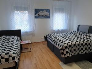 duas camas num quarto com duas janelas em KM Apartment em Triberg