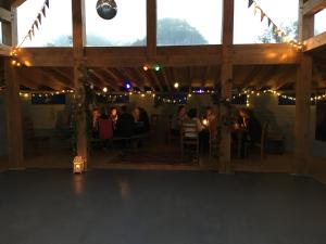 a group of people sitting in a barn with lights at Inch Hideaway Eco Camping in Whitegate