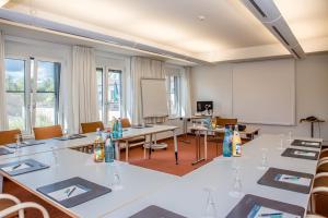 Seehotel Rheinsberg في راينزبرج: غرفة مع طاولات وكراسي وطاولة بيضاء
