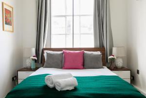 a bedroom with a bed with two towels on it at PickThePlace Lancaster gate in London