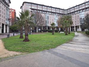 a park with palm trees in front of a building at Pardal12 By Vigovacaciones in Vigo