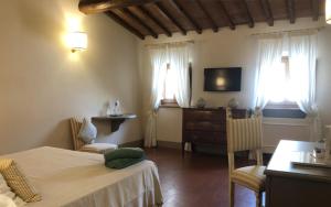a bedroom with a bed and a dresser and windows at Castello Vicchiomaggio in Greve in Chianti