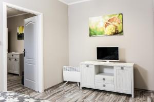 a bedroom with a bed and a desk with a television at GÁRDI APARTMAN in Szekszárd