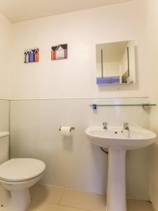 a white bathroom with a toilet and a sink at Lost Guest House Aberdeen in Aberdeen