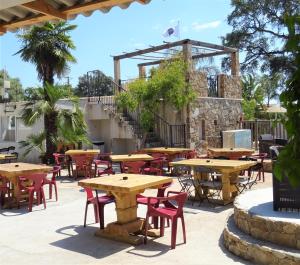 an outdoor patio with wooden tables and chairs at Camping Via Romana in Prunelli-di-Fiumorbo