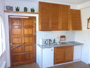 a kitchen with a sink and a wooden door at Apartment Hibiscus Cadaqués in Cadaqués +9 photos