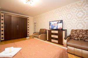 モスクワにあるApartment on Elninskaya 15のベッド、テレビ、ソファが備わる客室です。