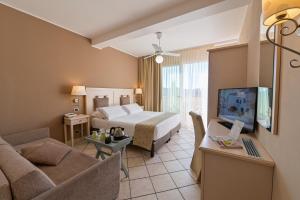 una camera d'albergo con letto e soggiorno di Hotel Liliana Diano Marina a Diano Marina
