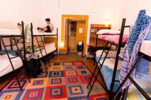 a room with several bunk beds and a man sitting on a desk at SUNSHINE HOSTEL in Rome