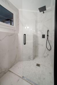 W łazience znajduje się prysznic ze szklanymi drzwiami. w obiekcie SUITE DESNOS : au cœur de la Rive Gauche, neuf, design, 2 personnes w Paryżu