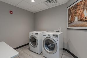 een wasruimte met een wasmachine en een schilderij bij Holiday Inn Mishawaka by IHG in Mishawaka