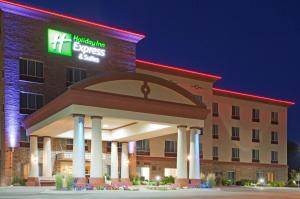 a hotel with a sign on the front of a building at Holiday Inn Express & Suites Wausau, an IHG Hotel in Weston