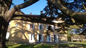 um grande edifício branco com uma árvore em frente em Château La Violette em Les Marches